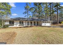 Charming ranch-style home featuring a brick exterior and lush, mature trees in a well-maintained front yard at 4178 Castle Pines Ct, Tucker, GA 30084