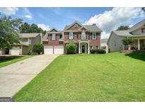 Traditional two-story brick home with a well-manicured lawn and a two-car garage at 412 Middlebrooke St, Canton, GA 30115
