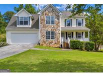 Charming two-story home with stone accents, manicured lawn, and attached two car garage at 684 Doe Lane Ln, Loganville, GA 30052