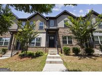 Inviting two-story townhome featuring a brick facade, landscaped yard and welcoming front entrance at 1004 Bayrose Cir, East Point, GA 30344