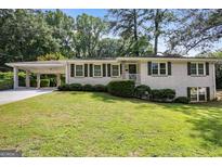 Charming single-story home featuring a white brick facade, covered carport, and a well-maintained lawn at 2855 Briarlake Ne Rd, Atlanta, GA 30345