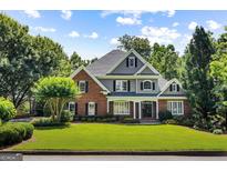 Stately brick and gray home with lush green lawn, offering classic curb appeal and mature landscaping at 125 Franklin Pl, Atlanta, GA 30342