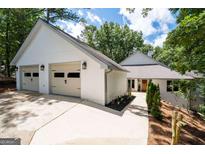 Beautiful home exterior with a two-car garage, manicured landscaping, and a charming pathway at 145 Mount Shasta Ln, Johns Creek, GA 30022