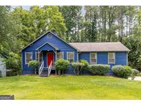 Charming blue home with a well-maintained lawn and landscaped greenery all around at 178 Castleair Ne Dr, Kennesaw, GA 30144
