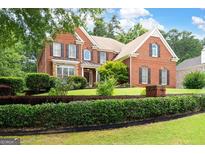 Brick two-story home featuring manicured lawn and dark shutters, enhancing curb appeal at 3045 Moss Stone Lane Sw Ln, Marietta, GA 30064
