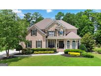 Stunning brick and stone home featuring manicured landscaping and a lush green lawn at 2230 Cambridge Hill Ct, Dacula, GA 30019