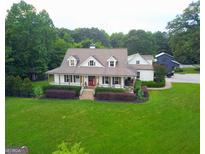 Charming home featuring a covered porch, landscaped yard, and classic architectural details at 7093 Vaughn Rd, Canton, GA 30115