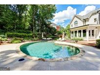 Backyard pool features a stone surround and patio furniture at 121 Fairway Overlook, Woodstock, GA 30188