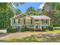Charming single-Gathering home with muted green siding, dark shutters, and a well-manicured front lawn at 113 Hitchcock Dr, Villa Rica, GA 30180