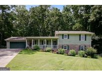 Charming two-story home with a well-maintained lawn and beautiful landscaping, including mature trees at 3359 Villa Ln, Douglasville, GA 30135