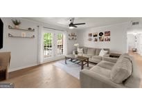 Bright living room with hardwood floors, ceiling fan, shelves, and French doors to the deck at 603 Brighton Pt, Atlanta, GA 30328