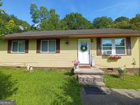Charming single-story home with yellow siding and a well-manicured lawn at 649 Mary Ln, Marietta, GA 30062