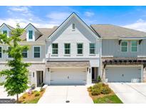 Beautiful townhome featuring a painted brick facade, two-car garage, and manicured landscaping at 1316 Willamette Way, Marietta, GA 30008