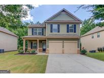 Charming two-story home features a two-car garage, and a well-manicured lawn at 2030 Beyers Landing Dr, Buford, GA 30519