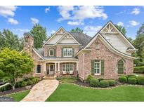 Beautiful brick two-story home with stone accents, manicured lawn, and a welcoming stone walkway at 3088 Hidden Falls Dr, Buford, GA 30519