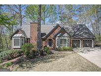 Charming brick home featuring a well-manicured lawn, bay windows, and an attached two car garage at 2689 Spring Rock Ne Ct, Roswell, GA 30075