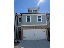 Charming two-story home showcasing a brick and siding exterior with a spacious two-car garage at 5615 Hislop Ln # 82, Mableton, GA 30126