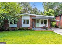 Charming brick home featuring a well-maintained lawn and inviting front porch at 222 Bishop Ne Dr, Marietta, GA 30060