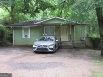 Cozy single-story home with a covered porch, green siding, and a car parked in the front at 118 Tye St, Stockbridge, GA 30281