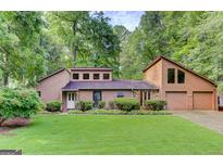 Charming two-story home with a well-manicured lawn, stone accents, and an attached two-car garage at 4920 Tremont Ne Dr, Marietta, GA 30066