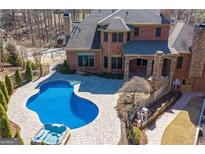 Beautiful backyard pool and patio area with lounge and a connected hot tub at 297 Collegiate Dr, Powder Springs, GA 30127
