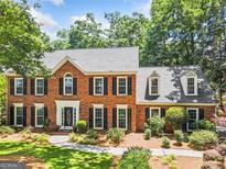 Beautiful two-story brick home with a well-manicured front yard and mature trees at 3506 Billingsley Dr, Marietta, GA 30062
