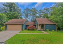Charming home with a two-car garage, complemented by a well-manicured lawn and vibrant shrubbery at 959 Sweet Briar Se Trl, Conyers, GA 30094