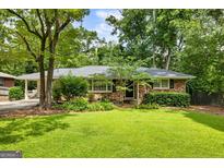 Charming brick home featuring a well-manicured lawn and lush landscaping, creating inviting curb appeal at 2163 Medfield Ne Trl, Chamblee, GA 30345