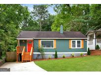 Charming home featuring a bright red front door and quaint, cottage-style landscaping and a concrete driveway at 1258 Campbellton Sw Rd, Atlanta, GA 30310