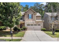 Charming home featuring a stone facade, a two-car garage, and lush landscaping at 2780 Lakeview Walk, Decatur, GA 30035