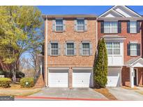 Charming two-story townhouse with red brick facade, grey shutters, and two-car garage at 420 Heritage Park Nw Trce # 22, Kennesaw, GA 30144
