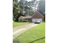 Charming single-story home with a brick facade, a well-maintained lawn, and an attached two-car garage at 7133 Babbling Brook Dr, Jonesboro, GA 30236