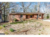 Charming brick home with a quaint front yard and mature trees, creating a welcoming curb appeal at 2522 Frost Sw Dr, Marietta, GA 30008