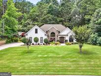 Charming one-story home featuring stone accents, mature landscaping, and a spacious front yard at 264 Line Creek Cir, Sharpsburg, GA 30277