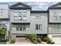 Modern townhome features a gray exterior, large windows, and attached garage with ivy climbing the facade at 698 Eustace Se St, Atlanta, GA 30315