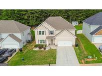 Two-story home featuring a two-car garage, manicured lawn, and neutral-toned siding at 232 Shelton Cir, Temple, GA 30179