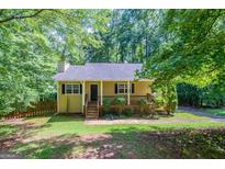 Charming single Gathering home with a covered porch, complemented by a lush, green front lawn and mature trees at 5341 Terrytown Ln, Lithonia, GA 30038