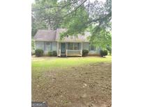Charming single-story home with a covered porch, blue shutters, and a classic design, nestled in a green yard at 220 Peach Forest Pl, Douglasville, GA 30134