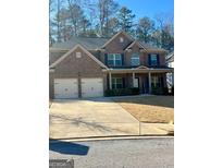 Traditional brick home with attached two car garage, covered porch, and well maintained lawn at 2208 Ginger Lake Ne Dr, Conyers, GA 30013