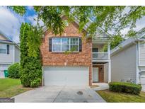Charming two-story brick home with a well-maintained lawn and attached garage in a quiet neighborhood at 513 Shadow Valley Ct, Lithonia, GA 30058