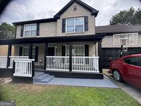 Charming brick two-story home with a covered front porch and black trim details at 595 Castlebrooke Dr, Lawrenceville, GA 30045