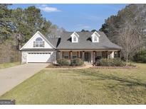 Charming home featuring a brick and siding facade, gabled roof, and manicured landscaping at 950 Besse Way, Locust Grove, GA 30248