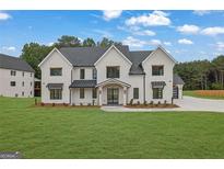 New construction home with painted brick exterior, black trim, and lush green lawn at 3893 Indian Shoals Road, Dacula, GA 30019