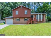 Charming two-story home with brick and wood exterior and lush green lawn at 5207 Shawn Ln, Stone Mountain, GA 30088