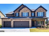 Two-story brick home featuring a three-car garage, black shutters and a manicured lawn at 1172 Faulkner Way, Jonesboro, GA 30238