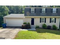 Charming home with a manicured lawn, two-car garage, and traditional curb appeal at 120 E Cainwood E Ct, Atlanta, GA 30349