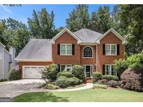 Charming brick home with lush landscaping and a well-manicured lawn creating great curb appeal at 1884 Whitehawk Ct, Lawrenceville, GA 30043