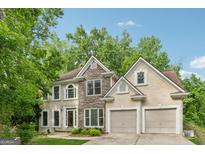 Charming two-story home with stone accents, manicured lawn, and an attached two-car garage at 3355 Golfe Links Dr, Snellville, GA 30039