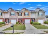 Charming townhomes with brick and stone accents, individual garages, and well-maintained lawns at 2083 Hasel St, Lawrenceville, GA 30044