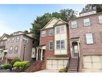 Charming brick townhome featuring a two-car garage and well-maintained landscaping at 2084 Cobblestone Ne Cir, Brookhaven, GA 30319